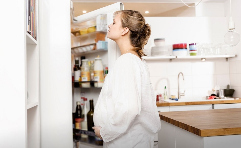 pregnant woman looking in the fridge